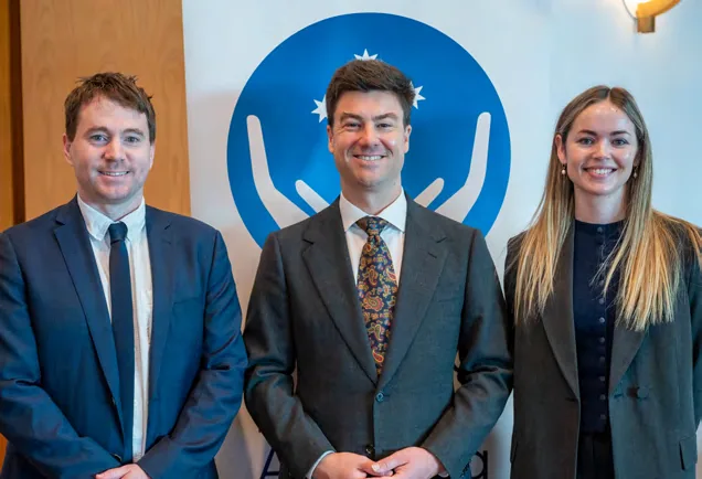 Alex Lynch, Minister Sam Rae MP and Dr Megan Eustace in front of the CHA logo in Canberra