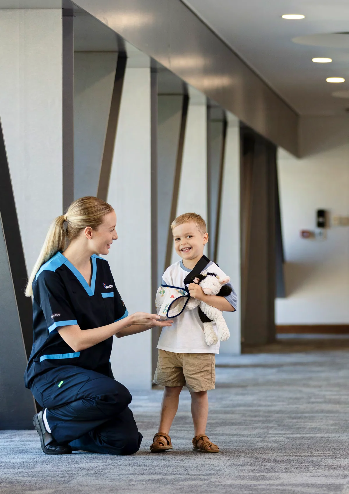 A Mater Brisbane nurse with a young patient holding a soft toy