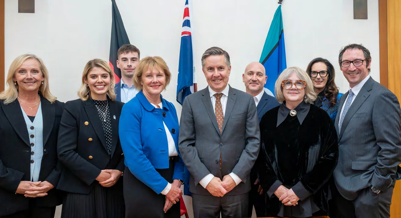 CHA members and staff standing with Health Minister Mark Butler MP in front of flags in Canberra