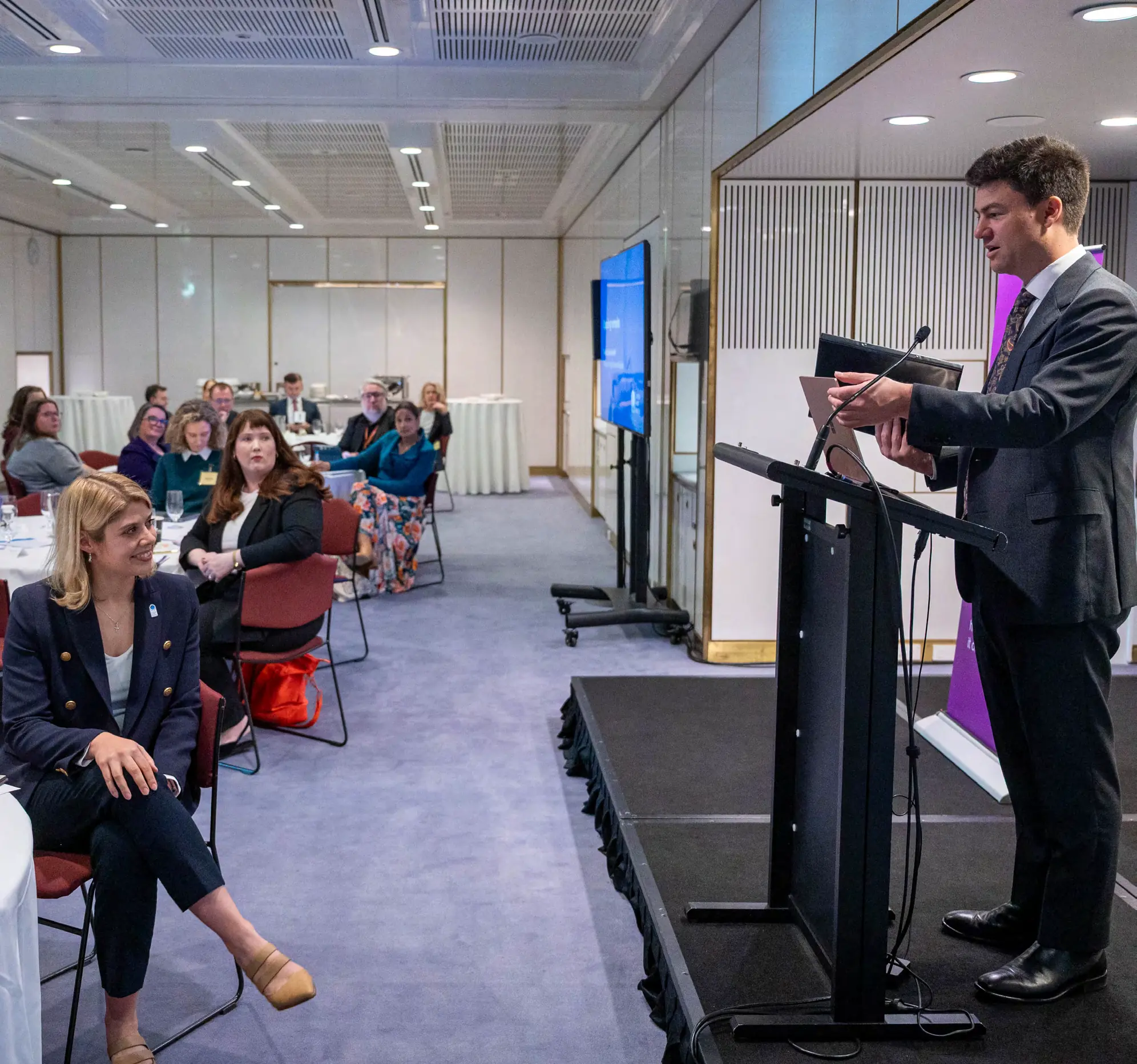 The Hon Sam Rae MP speaking at a lectern to a seated audience at a Catholic Health Australia roundtable
