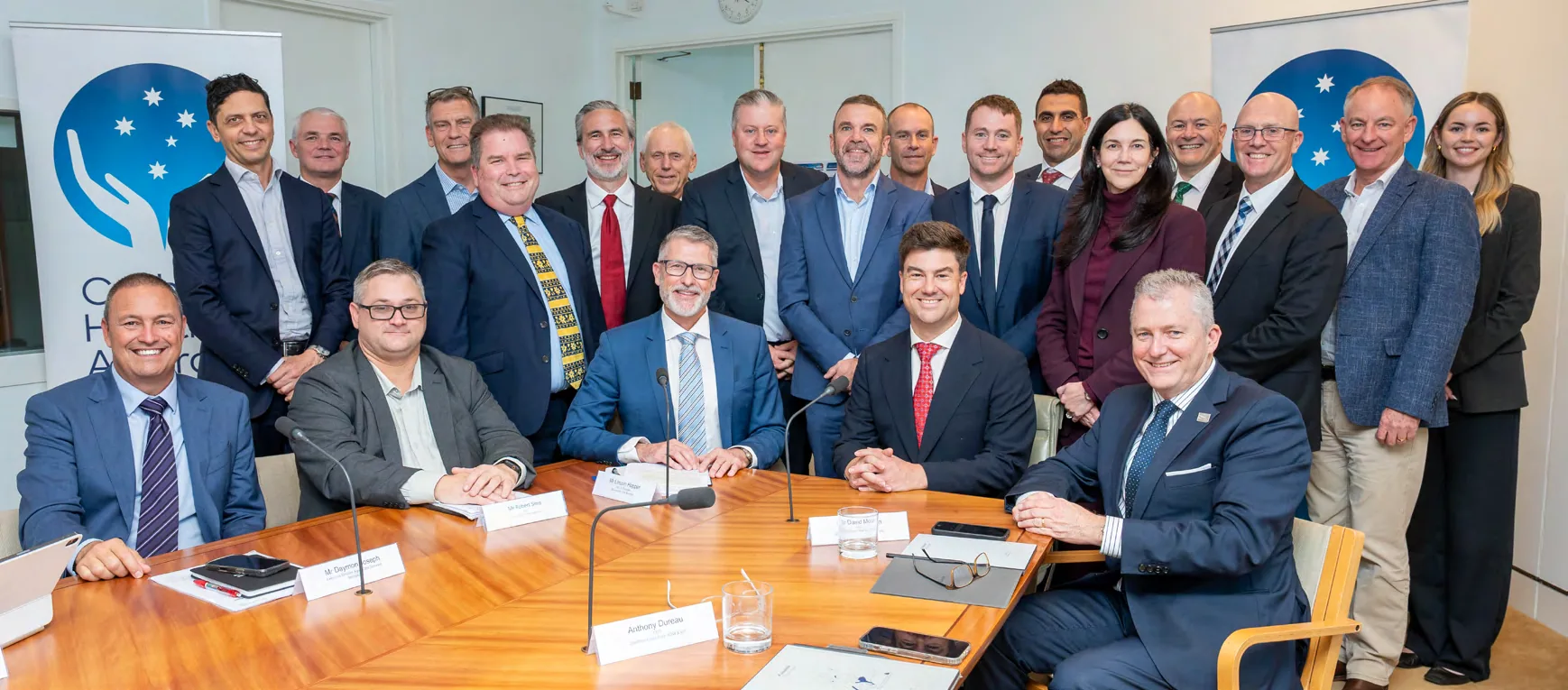 Attendees of CHA&rsquo;s Parliamentary Roundtable seated and standing around a boardroom table in Canberra